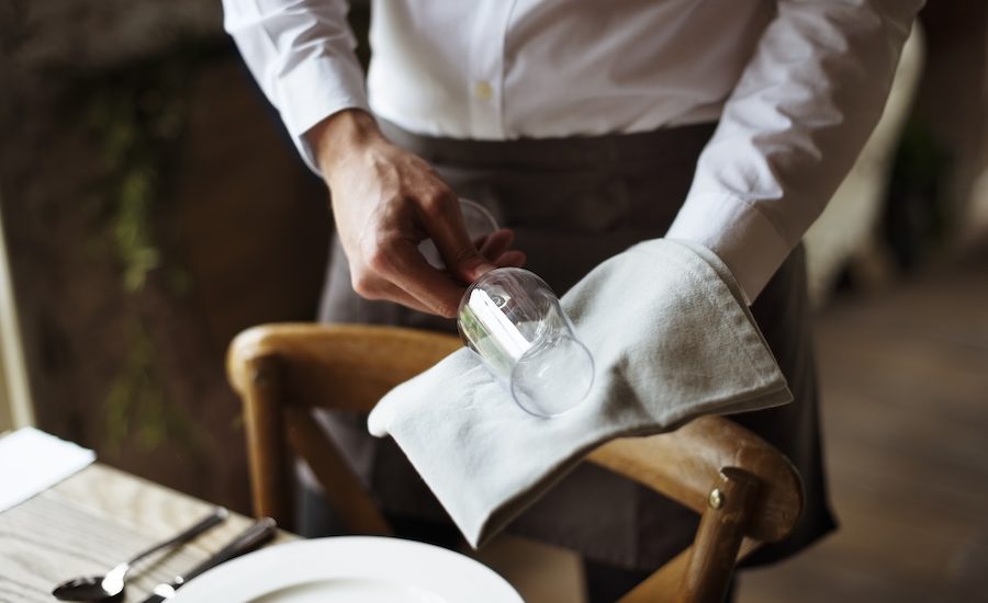 A waiter polishing a glass at a California fine dining restaurant.